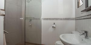 a bathroom with a shower and a toilet and a sink at StableWood Lodge in Kimberley +187 photos