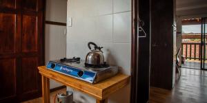 Una tetera colocada encima de una estufa en StableWood Lodge, en Kimberley