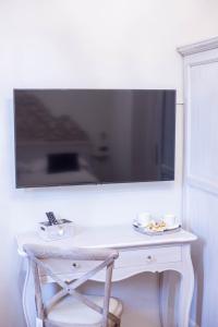 a white desk with a chair and a tv on a wall at Residenza Florentia in Florence