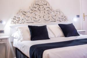 a large white bed with a large white headboard at Residenza Florentia in Florence