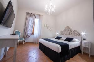 a bedroom with a large bed and a chandelier at Residenza Florentia in Florence