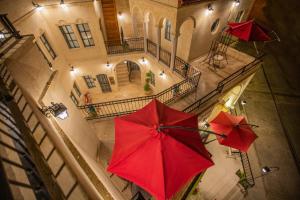 dois guarda-chuvas vermelhos em frente a um edifício em Sinasos Star Hotel em Urgup