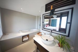 ein Badezimmer mit einem Waschbecken, einem Spiegel und einer Badewanne in der Unterkunft Sapa Panorama Hotel in Sa Pa