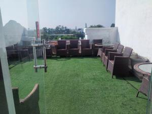 a group of chairs and tables on a balcony at Le Roi Jammu - Near Jammu Railway Station in Jammu