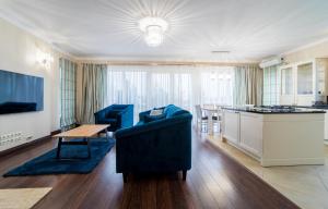 Una sala de estar con un sofá y una mesa y una cocina. en Apartament Villa Resorts, en Dziwnówek
