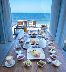 a dining room table with plates of food on it at Caravana Beach Resort Al Zorah in Ajman 