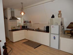 a kitchen with white cabinets and a white refrigerator at Het Speijerhuis in Harlingen