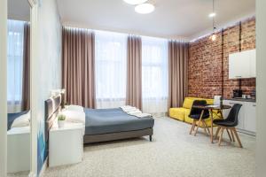 a bedroom with a bed and a yellow couch at Gruda Apartments, ŚNIADANIA, Bezpłatny Parking, Faktury VAT in Kwidzyn