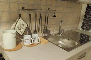 um balcão de cozinha com um lavatório e chávenas e utensílios em Sanremo Dream - Teo House em Sanremo
