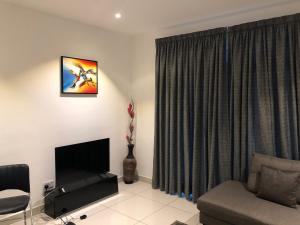 a living room with a tv and a couch and a window at Embassy Gardens by Clifton in Accra