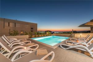 - un groupe de chaises longues et une piscine dans l'établissement Sanda luxury apartment with pool, à Novalja