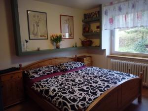sypialnia z łóżkiem z czarno-białą kołdrą w obiekcie Apartmán Na sluneční stráni w Trutnovie