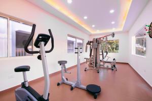 a gym with treadmills and exercise bikes in a room at Pleasant Hill Resort in Munnar