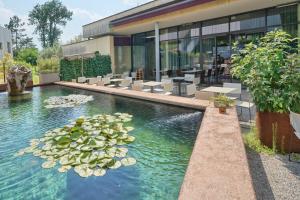 a pool with water lilies in front of a building at Villa Tranquillini auf Gut Guntrams in Schwarzau am Steinfelde