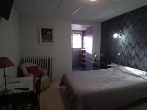 1 dormitorio con cama, silla y escritorio en hôtel Piellenia, en Tardets-Sorholus