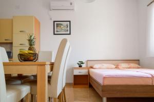 a bedroom with a bed and a table with a bowl of fruit at Apartments Turić in Promajna