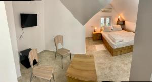 um quarto com uma cama, uma televisão e uma mesa em Hostel JAZ em Bucareste