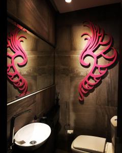 a bathroom with a sink and red signs on the wall at GATE Recoleta in Buenos Aires +25 photos