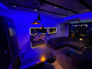a living room with purple lighting and a couch at GATE Recoleta in Buenos Aires