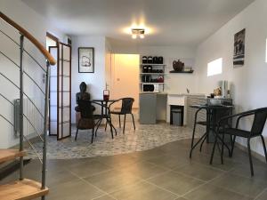 uma sala de estar com mesa e cadeiras e uma cozinha em Relais du Chat Prosper em Lescherolles