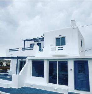 a white house with a blue door at Karma Suites in Ftelia