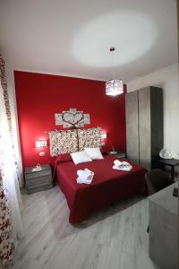 1 dormitorio rojo con 1 cama con pared roja en B&B ANGELO, en Caltanissetta