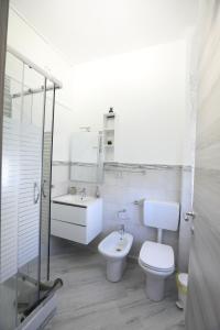 biała łazienka z toaletą i umywalką w obiekcie B&B ANGELO w mieście Caltanissetta +6 zdjęć