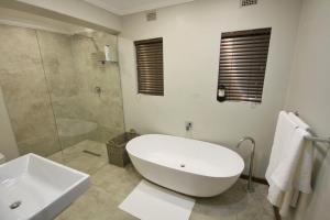 een badkamer met een bad, een douche en een wastafel bij Crestwood Bed & Breakfast in Curryʼs Post