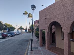a street light on a sidewalk next to a building at Renovated apartment on beachside with pool in Nerja