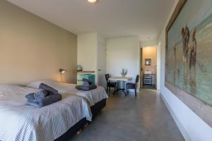 a bedroom with two beds and a table with chairs at Ride by the Sea Guesthouse in Koudekerke