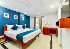 1 dormitorio con 1 cama grande y paredes azules en The Reach Hotel, en Kochi