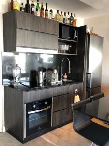a black kitchen with a stove and a refrigerator at GATE Recoleta in Buenos Aires