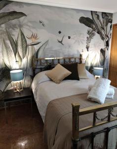 a bedroom with a bed with plants on the wall at Apartamento Plaza Mayor Trujillo in Trujillo