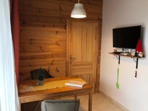 Habitación con mesa de madera, TV y escritorio. en Haus Edelgrün en Tauplitz