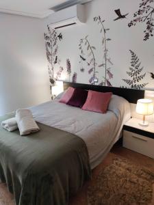 a bedroom with a large bed with pink pillows at Apartamento Plaza Mayor Trujillo in Trujillo +7 photos
