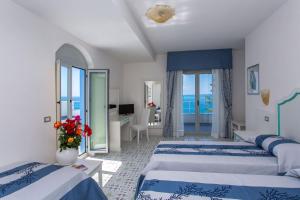 a hotel room with two beds and a view of the ocean at Hotel Ferretti in Diamante