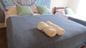 Una cama con dos toallas blancas encima. en Guaiamu Suítes Ilhabela en Ilhabela