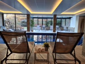 a lobby with two chairs and a bar with a table at Maison Jenny Hotel Restaurant & Spa in Hagenthal-le-Bas