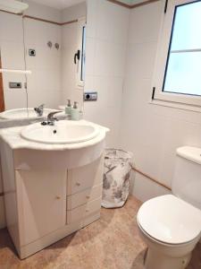 ein Bad mit einem Waschbecken, einem WC und einem Fenster in der Unterkunft Apartamento Plaza Mayor Trujillo in Trujillo