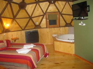 1 dormitorio con cama y bañera en Domos Puelo en Lago Puelo