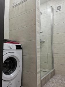 uma máquina de lavar roupa na casa de banho com um chuveiro em НОВАЯ КВАРТИРА на пр. Соборном возле ЗНУ em Zaporozhye