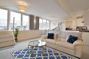 uma sala de estar com um sofá e uma mesa em Scarborough-Penthouse, with private balcony, lift and parking em Scarborough