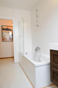 a white bathroom with a sink and a mirror at Les Cerisiers - Duplex de Standing au Centre de Namur in Namur