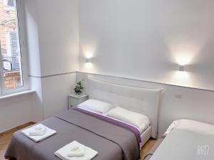 ローマにあるゴールデン レイシオのベッド2台と窓が備わる小さな客室です。