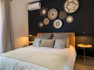 sypialnia z łóżkiem z zegarami na ścianie w obiekcie Villa Miss Satô w mieście Ravine des Cabris
