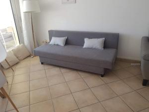 - un canapé dans le salon avec 2 oreillers dans l'établissement Appartement Standing Marseille 2 chambres 6 pers Clim Parking JO, à Marseille