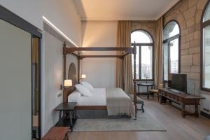 a bedroom with a canopy bed and a piano at Parador de Turismo de León in León