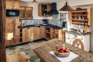 una cocina con armarios de madera y una mesa con fruta. en Bauernhof Wachter en Fiss