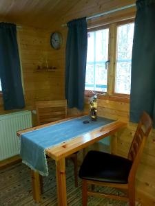 a dining room with a wooden table with a blue cloth on it at Bakkakot 2 - Cozy Cabins in the Woods in Akureyri