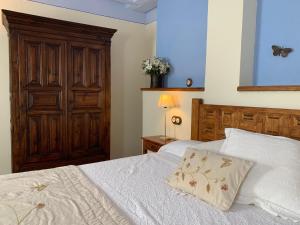 a bedroom with two beds and a wooden cabinet at Caserío de Fatás in Navasa